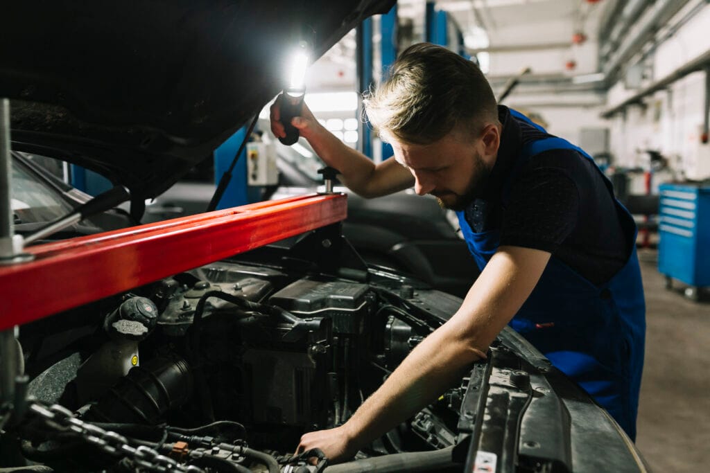 auto mechanic looking cars engine room